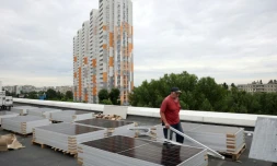 Un ouvrier installe des panneaux solaires sur le toit d'une maternité au cours d'une coupure d'électricité à Kiev en Ukraine, le 14 juin 2024, à la suite d'attaques russes contre des infrastructures électriques