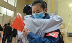 Une soignante de Xiaogan, ville de la province du Hubei au coeur de l'épidémie de coronavirus, dit au-revoir à une collègue venue prêter main forte depuis Chongquing, le 23 mars 2020 à Xiaogan