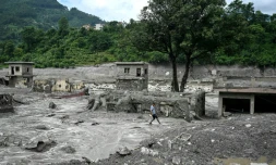 Un homme marche au milieu des décombres aprÚs la crue destructrice dans l'Himalaya, le 30 août 2026 à Trishuli, dans le district népalais de Nuwakot