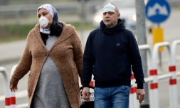 Des habitants équipés de masques de protection photographiés le 23 février 2020 à l'entrée de la petite ville de Casalpusterlengo, près de Milan en Italie, pays le plus touché en Europe par le coronavirus