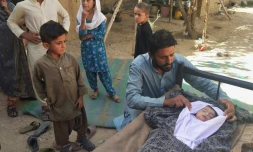 Un père auprès du corps de son fils décédé suite à l'effondrement d'un toit causé par un séisme de magnitude 5,9 dans la région d'Harnai au Pakistan, le 7 octobre 2021