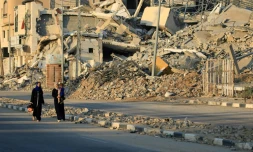 Des Palestiniennes marchent au milieu des ruines dans le camp de Bureij, dans le centre de la bande de Gaza, le 12 juin 2024