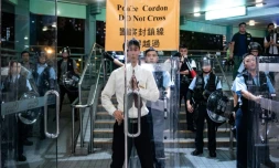 Un agent de sécurité ferme les portes d'une galerie commerciale lors d'une manifestation à Hong Kong, le 13 juillet 2019