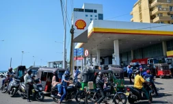 Des motoyclistes font la queue pour prendre du carburant à une station-service de Wellawatte, près de Colombo, le 16 mars 2026 au Sri Lanka 