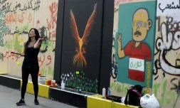Une artiste libanaise Hayat Nazer devant son phoenix peint sur le mur, le 6 novembre 2019 à Beyrouth