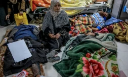 Une femme se tient parmi des Palestiniens blessés à l'hÎpital d'al-Chifa, le 29 février 2024 à Gaza-ville dans la bande de Gaza