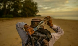 Photo du 16 septembre 2020 de Tengku Mohamad Ali Mansor en train de ramasser des bouteilles sur une plage de l'est de la Malaisie.