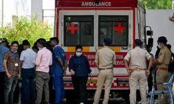 Des policiers et des membres du personnel médical près d'une ambulance stationnée devant une morgue d'hôpital à Ahmedabad, le 15 juin 2025