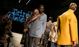 Des demandeurs d'asile défilent sur le podium du salon Pitti Uomo le 14 janvier 2016 à Florence