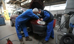 Un mécanicien et un apprenti travaillent dans un garage à Hérouville-Saint-Clair, dans le Calvados, le 24 avril 2008