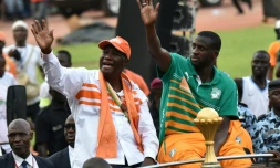 Le président ivoirien Alassane Ouattara avec le capitaine de l'équipe nationale Yaya Touré et le trophée de la CAN-2015, le 9 février 2015 à Abidjan