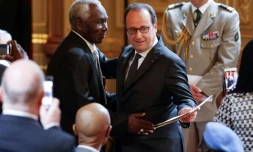 Le président François Hollande (d) lors d'une cérémonie réintégrant 28 tirailleurs sénégalais dans la nationalité française, le 15 avril 2017 à Paris