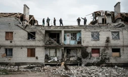 Des ouvriers évacuent des débris d'un immeuble bombardé de Cherkaske (est de l'Ukraine), le 11 mai 2022