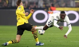 L'attaquant du Paris SG Randal Kolo Muani (D) est taclé par le défenseur du Borussia Nico Schlotterbeck, lors d'un match de Ligue des champions, le 13 décembre 2023