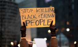 Un manifestant à Chicago le 2 avril 2018, proteste contre les meurtres de Noirs par la police américaine  