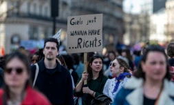 Une manifestante brandit une pancarte proclamant "Grils just wanna have... rights" ("Les filles veulent juste avoir des droits"), lors de la manifestation pour la journée internationale des droits des femmes, le 8 mars 2025 à Paris