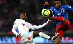 Le milieu de Marseille Bouna Sarr (g) à la lutte avec le défenseur de Caen Emmanuel Imorou au stade Michel d'Ornano, le 17 janvier 2016