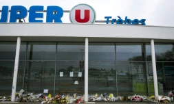 Des fleurs déposées en mémoire des victimes de l'attentat devant le supermarché Super U de TrÚbes dans le sud de la France, le 6 avril 2018