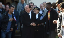 Le président François Hollande entouré de migrants lors d'une visite le 29 octobre 2016 au Centre d'Acceuil et d'Orientation de Doué-la-Fontaine