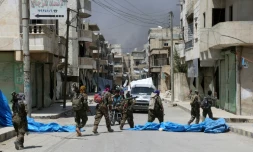 Des membres des forces démocratiques syriennes (FDS) patrouillent dans la ville de Minbej, le 7 août 2016 à la recherche de combattants de l'EI