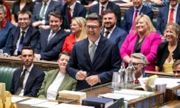 Photo diffusée par le Parlement britannique du nouveau député travailliste de Makerfield, Andy Burnham (c), souriant, après avoir signé le registre à la suite de sa prestation de serment à la Chambre des communes, le 22 mai 2026 à Londres 