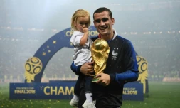 L'attaquant français Antoine Griezmann pose avec sa fille et la Coupe du monde, à l'issue de la finale le 15 juillet 2018 à Moscou