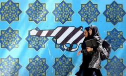 Des Iraniennes passent devant une peinture sur le mur de l'ancienne ambassade américaine à Téhéran, le 22 juin 2019