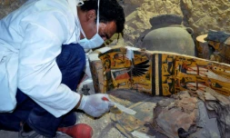 Un membre d'une équipe archéologique égyptienne travaille sur un cercueil en bois découvert dans une tombe de 3.500 ans dans la nécropole de Draa Abul Nagaa, près de Louxor, le 18 avril 2017