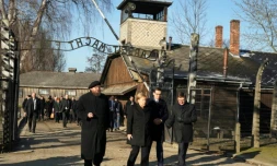 La chancelière allemande Angela Merkel (2è g) avec le Premier ministre polonais Mateusz Morawiecki (2è d) et le directeur du musée de Auschwitz-Birkenau Piotr Cywinski (g) franchit l'entrée du camp de l'ancien camp de Auschwitz-Birkenau, le 6 décembre 2019