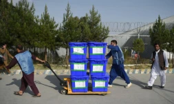 Des membres de la commission électorale indépendante transportent des bulletins de vote pour qu'ils soient comptabilisés, le 2 octobre 2019 à Kaboul en Afghanistan