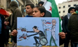 Une jeune Syrien porte une pancarte avec une caricature représentant les présidents russe Vladimir Poutine et syrien Bachar al-Assad, lors d'une manifestation le 21 février à Idleb, dans le nord-ouest de la Syrie