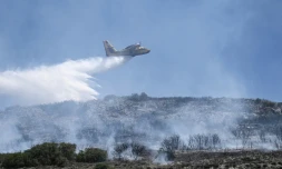 Un avion Canadair largue sa cargaison d'eau sur un incendie de forĂȘt prĂšs de Volos, le 27 juillet 2023 en GrĂšce