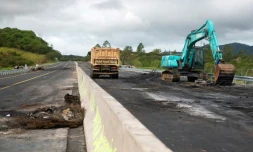 Des engins de chantier enlèvent des débris sur la route RT1 qui mène à l'aéroport international de Nouméa, le 19 mai 2024