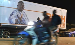 Des militants burkinabè fêtent la victoire à la présidentielle de Roch Marc Christian Kaboré (arrière-plan) à Ouagadougou le 1er décembre 2015