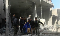 Des habitants de Hamouria transportent le corps d'une victime après un bombardement, dans la Ghouta orientale, le 3 décembre 2017 en Syrie