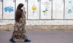 Une femme passe devant les symboles de partis politiques concourant aux élections marocaines, à Rabat, le 26 août 2021