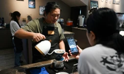 Liao Shihao sert du café à un client à la plantation de café Xiaowazi, le 1er avril 2025 à Pu'er, dans la province du Yunnan, dans le sud-ouest de la Chine