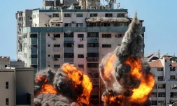 Des boules de feu jaillissent d'un bùtiment qui abritait les locaux de médias internationaux, pulvérisé par une frappe israélienne, le 15 mai 2021 à Gaza