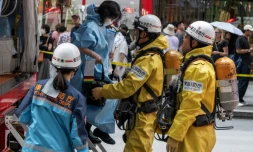 Les secours aident une femme qui était dans un centre commercial quand un homme y a pulvérisé une substance, à Tokyo, le 25 mai 2026