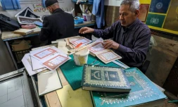 L'artisan Khaled al-Drebi (d) assemble les pages d'un vieux manuscrit dans son atelier oĂč il restaure des Corans anciens ou abĂźmĂ©s, le 22 mars 2022 Ă Tripoli, en Libye