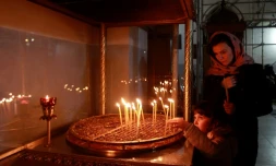 Une chrétienne et son fils allument des cierges le 20 décembre 2016 dansl'Eglise de la Nativité, à Béthléem en Cisjordanie, où Jésus-Christ est né selon la Bible