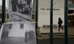 Des photos tirées de la vidéo d'un policier frappant un lycéen sont accrochées à la grille du lycée Bergson, le 24 mars 2016 à Paris 