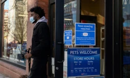Un homme porte un masque de protection à la sortie d'une boutique, le 26 janvier 2022 à New York