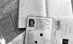 Photo du passeport d'Anne Frank posé sur des cahiers de son journal qu'elle écrivit dans les combles de la maison d'Amsterdam où elle était réfugiée avec ses parents pour échapper aux nazis entre juin 1942 et le 4 août 1944