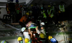 Des secouristes transportent une victime piégée sous les décombres de l'immeuble Sky Villa Condominium détruit à Mandalay, en Birmanie, le 30 mars 2025
