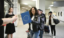 Des passagers arrivant de Berlin recoivent des drapeaux européen et bulgare aprÚs l'entrée partielle de la Bulgarie dans l'espace Schengen, à l'aéoport de Sofia le 31 mars 2024