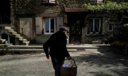 Un vieil homme rentre chez lui à Romans-Sur-Isère, le 17 avril 2020 après avoir fait ses emplettes auprès de l'épicier ambulant