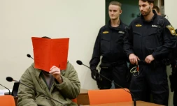 L'Afghan Farhad N. (g.), le visage caché derrière un dossier, est assis dans la salle d'audience du tribunal, le 16 janvier 2026 à Munich, pour le début de son procès pour avoir foncé en voiture dans la foule à Munich en 2025