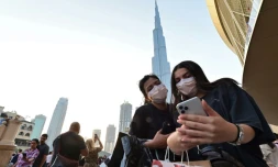 Des femmes avec des masques de protection devant la tour Burj Khalifa, à Dubaï, aux Emirats, le 8 mars 2020