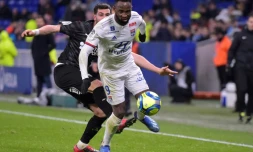 L'attaquant de Lyon Moussa Dembele devance le défenseur italien d'Amiens Arturo Calabresi, le 5 février 2020 à Décines-Charpieu, près de Lyon  